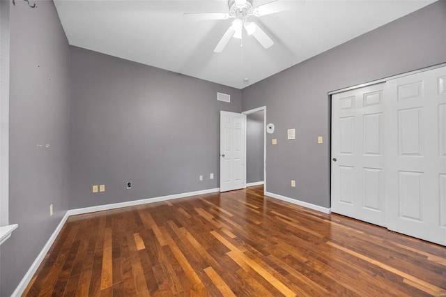 unfurnished bedroom with wood-type flooring, baseboards, visible vents, and a closet