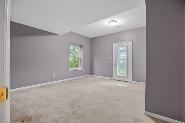 carpeted empty room featuring visible vents and baseboards