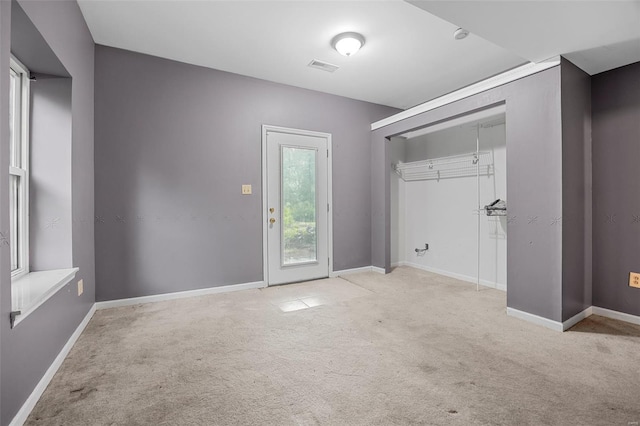 interior space with visible vents, carpet flooring, baseboards, and access to exterior