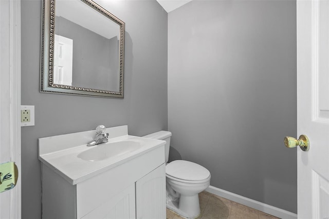 bathroom with vanity, tile patterned floors, baseboards, and toilet