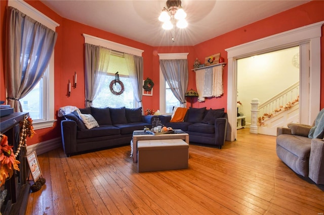 living room featuring stairs, a ceiling fan, plenty of natural light, and light wood finished floors