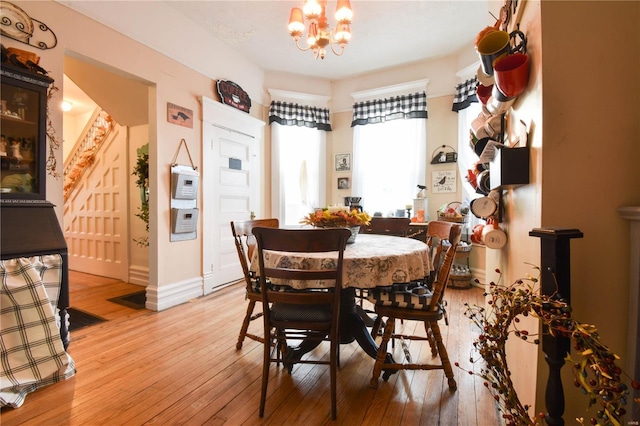 dining room with baseboards, light wood-style flooring, and a chandelier