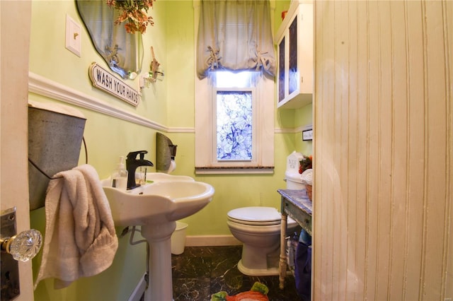 bathroom featuring toilet, baseboards, and marble finish floor