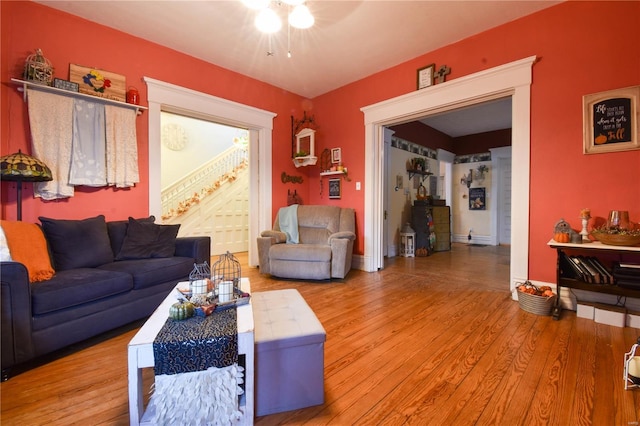 living area featuring baseboards, ceiling fan, and wood finished floors