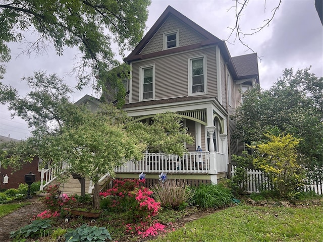 victorian-style house featuring fence and a porch