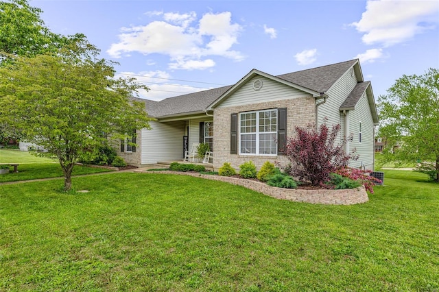 ranch-style house featuring a front yard, brick siding, roof with shingles, and covered porch