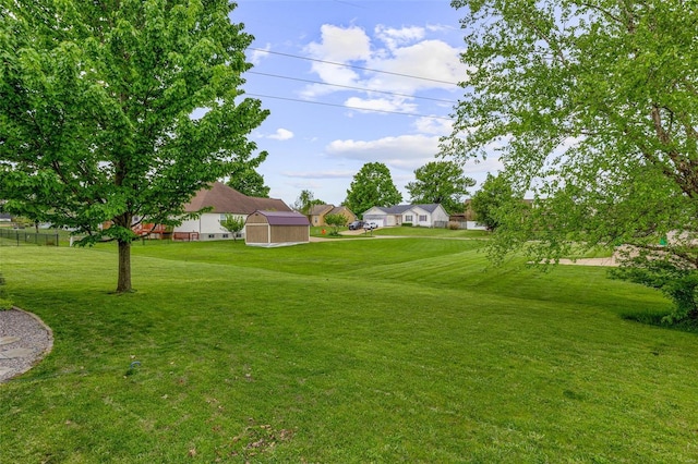 view of yard with a storage shed, an outbuilding, and a residential view