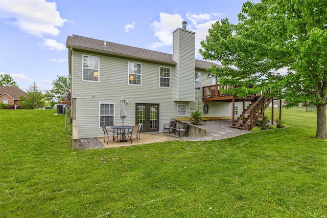 rear view of house featuring a lawn, stairway, a wooden deck, and a patio