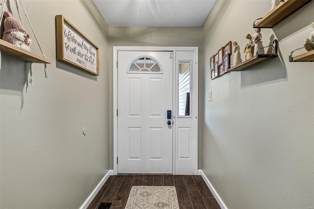 doorway with baseboards and dark wood finished floors