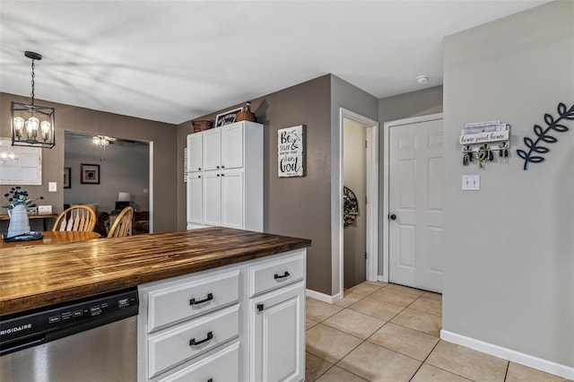 kitchen with dishwasher, baseboards, light tile patterned flooring, wood counters, and white cabinetry