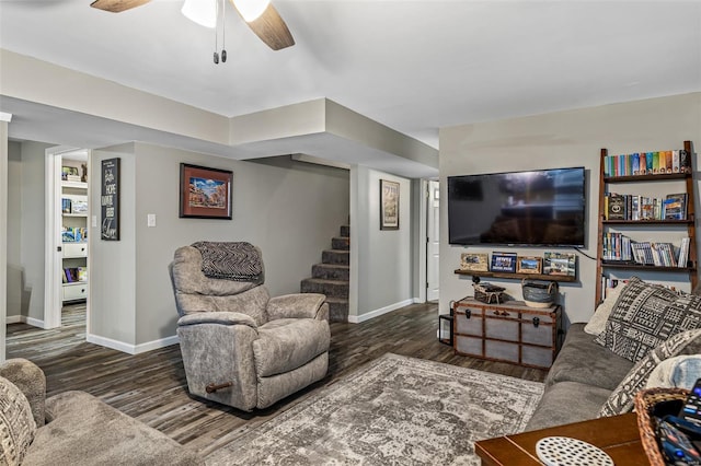 living area with baseboards, stairway, ceiling fan, and wood finished floors