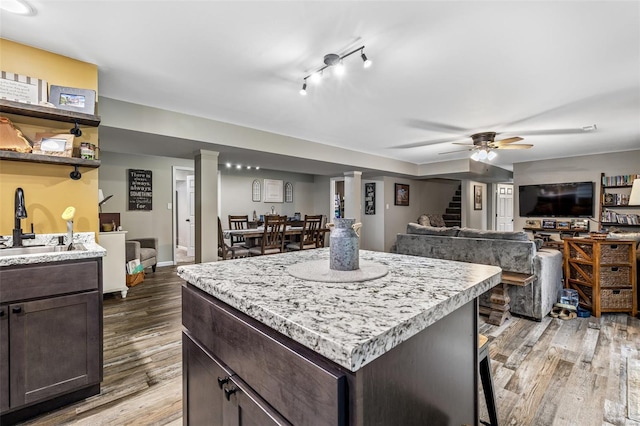 kitchen featuring light wood-style flooring, light countertops, and dark brown cabinets