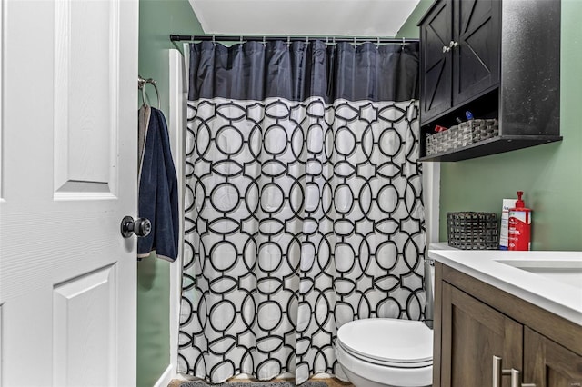bathroom featuring toilet, vanity, and a shower with shower curtain