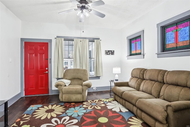 living room featuring baseboards, ceiling fan, and wood finished floors