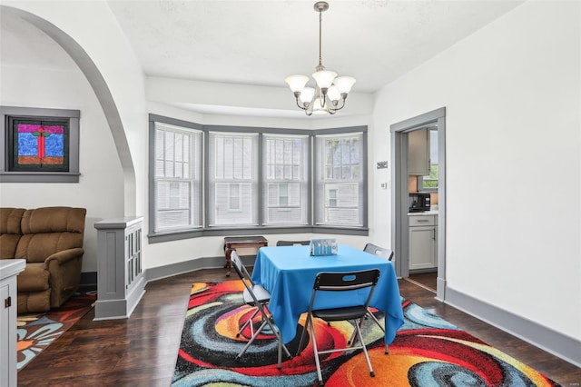 dining room featuring baseboards, a notable chandelier, and wood finished floors