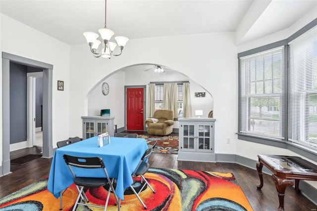 dining room featuring an inviting chandelier, arched walkways, baseboards, and wood finished floors