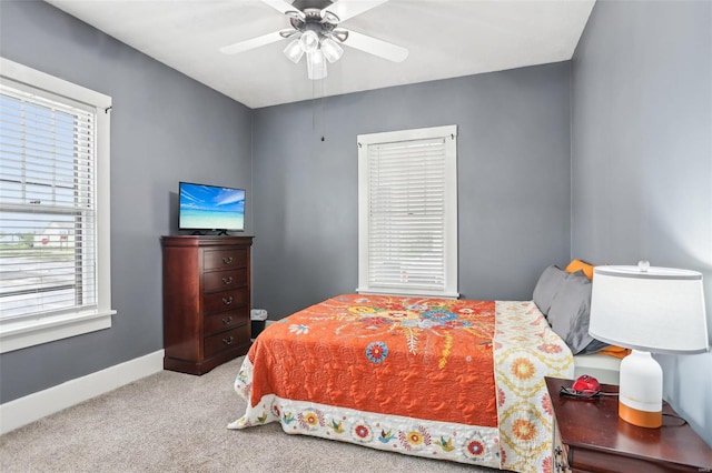 bedroom with baseboards, carpet flooring, a ceiling fan, and multiple windows