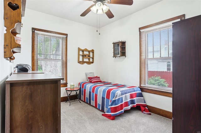 bedroom featuring a ceiling fan, baseboards, and light colored carpet