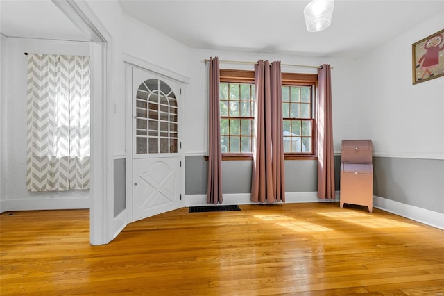 doorway with baseboards, light wood-type flooring, and visible vents
