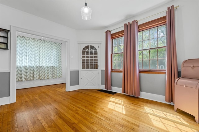 doorway to outside with baseboards, light wood-style flooring, and visible vents