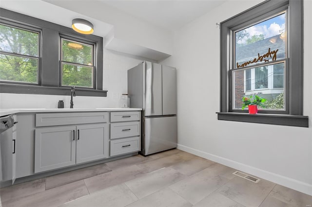 kitchen with freestanding refrigerator, visible vents, plenty of natural light, and a sink