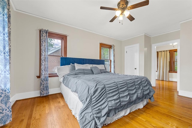 bedroom with ornamental molding, light wood finished floors, and multiple windows