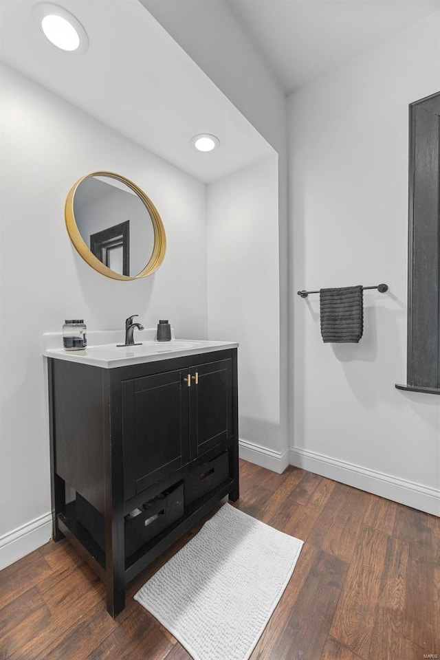 bathroom featuring baseboards, vanity, and wood finished floors