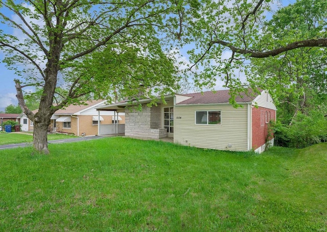 rear view of property featuring a yard and stone siding