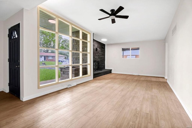 unfurnished living room with visible vents, ceiling fan, and wood finished floors