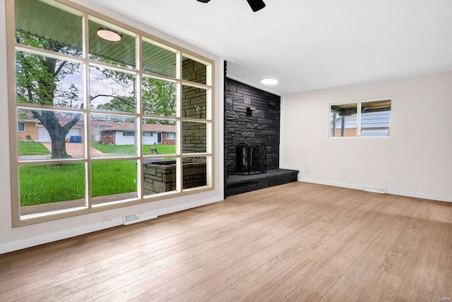 unfurnished living room featuring visible vents, baseboards, and ceiling fan