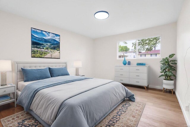 bedroom with baseboards and light wood finished floors