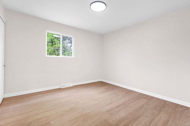 unfurnished room with baseboards, visible vents, and light wood finished floors