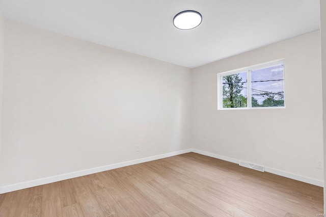 empty room with baseboards and light wood-style flooring