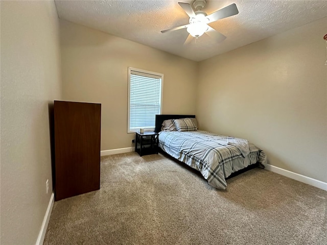 carpeted bedroom featuring a textured ceiling, baseboards, and a ceiling fan