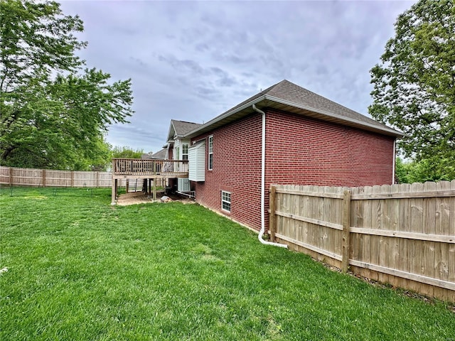 back of property with a lawn, brick siding, cooling unit, a wooden deck, and a fenced backyard