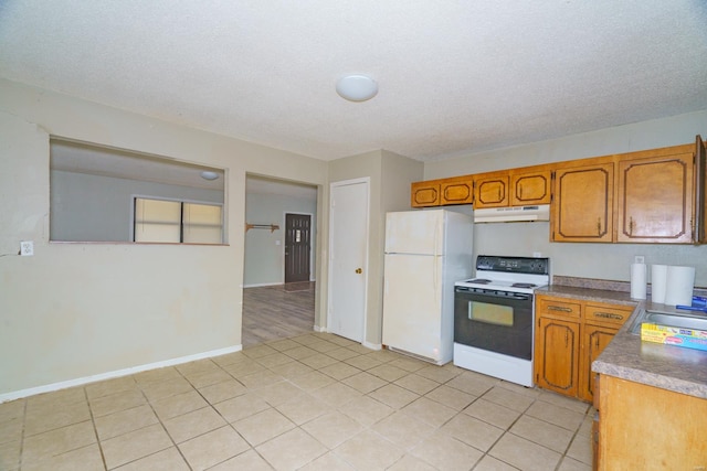 kitchen with freestanding refrigerator, brown cabinetry, range with electric stovetop, and under cabinet range hood