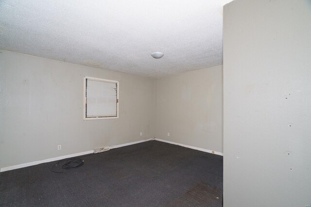 empty room with baseboards, carpet floors, and a textured ceiling