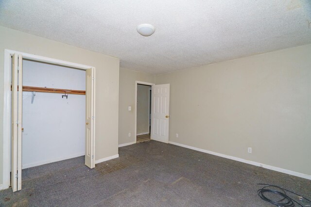 unfurnished bedroom with a closet, a textured ceiling, baseboards, and carpet floors