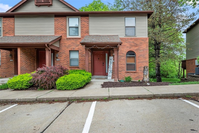 multi unit property featuring brick siding and uncovered parking
