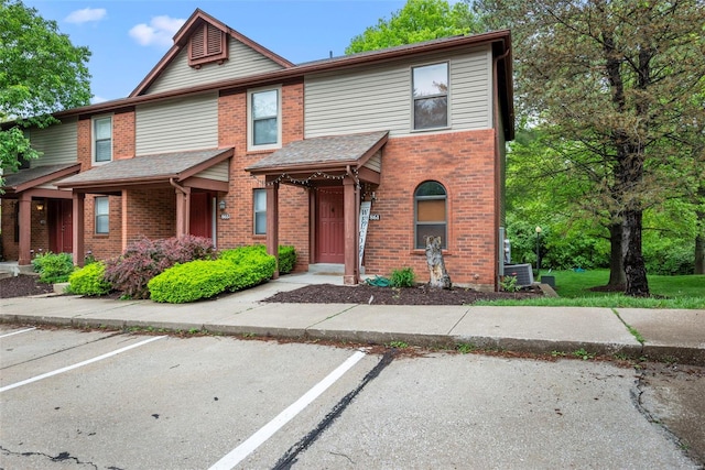 view of property featuring brick siding and uncovered parking