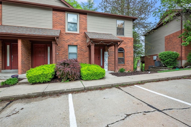 view of property featuring brick siding and uncovered parking