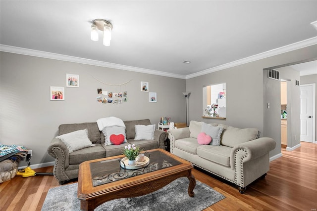 living area featuring crown molding, visible vents, and wood finished floors