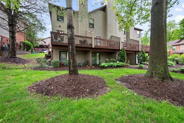 back of property with a chimney, a yard, and a deck