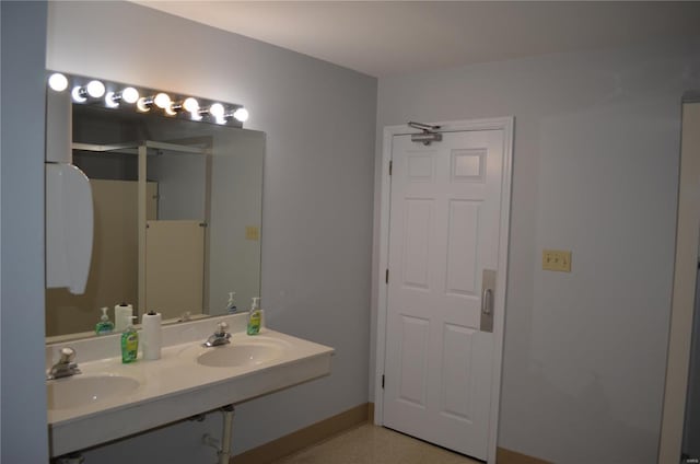 full bathroom featuring double vanity, a shower with door, and a sink