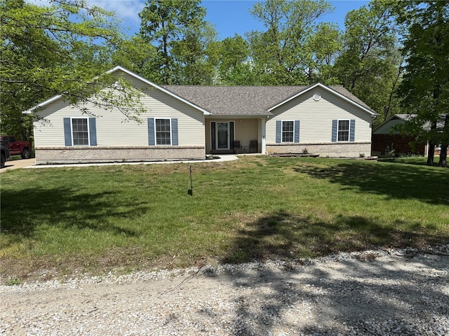 ranch-style home featuring brick siding, roof with shingles, and a front lawn