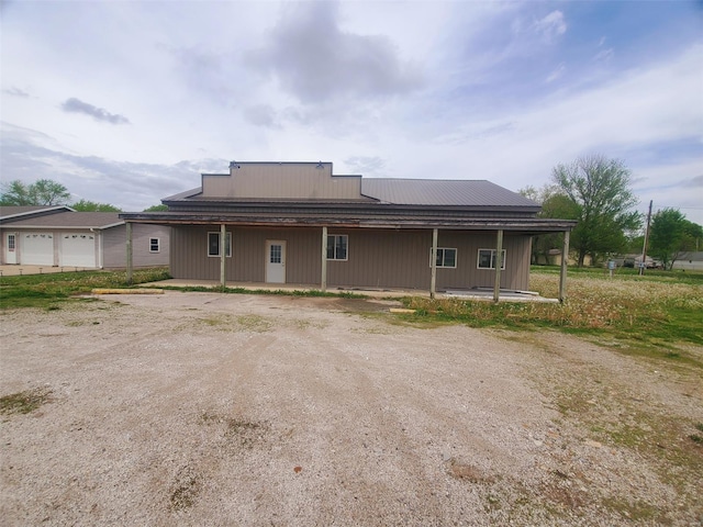 back of house with a porch and metal roof