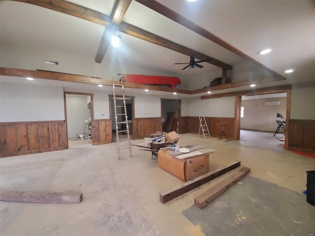 basement with recessed lighting, a ceiling fan, a wainscoted wall, and wooden walls