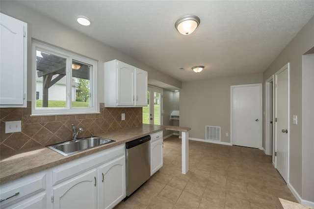 kitchen with a sink, dishwasher, white cabinetry, decorative backsplash, and visible vents