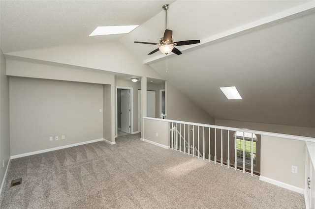 bonus room featuring baseboards, a ceiling fan, carpet, and lofted ceiling with skylight