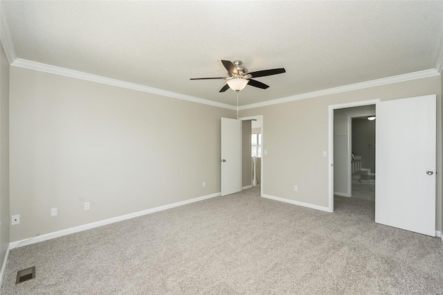 unfurnished room featuring ceiling fan, visible vents, ornamental molding, and baseboards